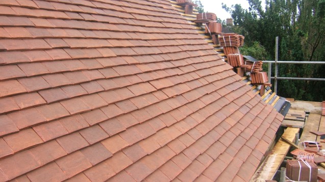 Clay tiles being laid on a pitched roof